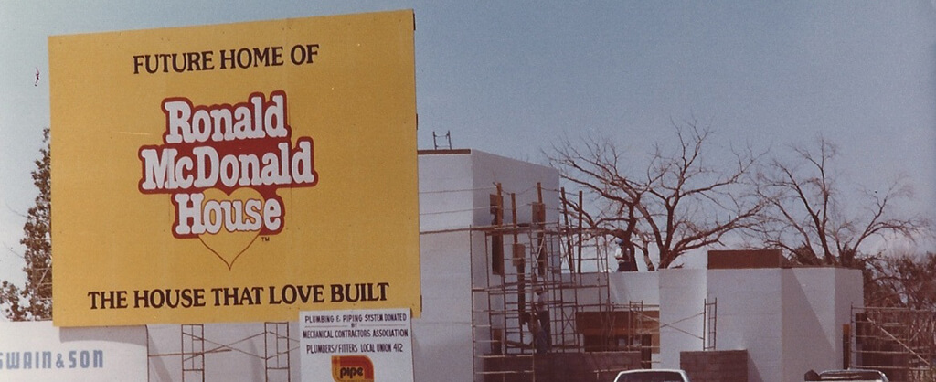 OUR-HISTORY-copy vintage picture of sign telling of future ronald McDonald's house under construction